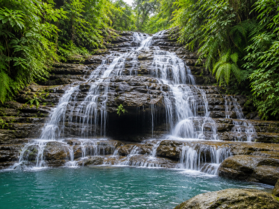 Goa Rangreng Waterfall in Ubud Bali with cascading rock formations and clear natural pool surrounded by lush tropical jungle